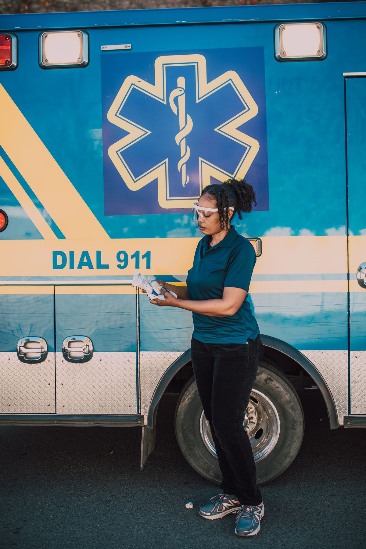 EMT in uniform standing beside an ambulance, ready for emergency response