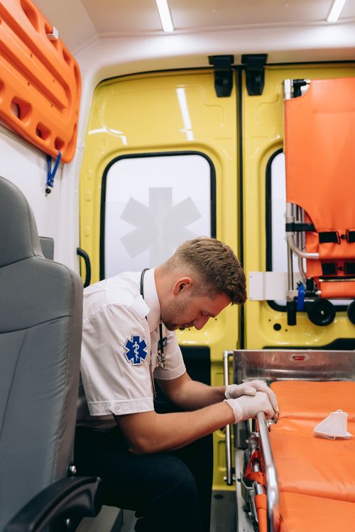 A paramedic resting inside an ambulance during a shift, showing the real work environment of EMS crews